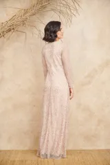 Vestido largo color rosado, con diseño de manga larga y cuello redondo, completamente bordado con lentejuelas y abalorios formando patrones geométricos y florales.