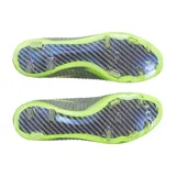 Championes de fútbol Under Armour Shadow Elite 3 FG, diseñados para terreno firme. Presentan una parte superior de tejido IntelliKnit en color gris con detalles en verde neón, logotipo de la marca en negro y suela de fibra de carbono con tapones transparentes.