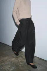 Pantalón de tiro medio confeccionado en mezcla de algodón, con diseño de corte recto y holgado. Presenta cintura con trabillas, cierre frontal con cremallera y botón, y bolsillos laterales ocultos en las costuras.