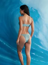 Conjunto de bikini lila con acabado brillante, compuesto por un corpiño con argolla y tiras ajustables para atar en los hombros, y una bombacha colaless con tiras laterales regulables.