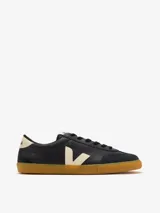 Championes Veja modelo Volley, de color negro con detalles en crema. Presentan el logo lateral característico de la marca en contraste, puntera reforzada de gamuza y suela de goma color caramelo.