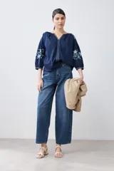 Blusa azul marino de estilo boho con escote en V, mangas 3/4 y bordados de flores en las mangas.