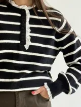 Sweater de punto a rayas horizontales en color bordó y blanco, con cuello tipo polo, cierre frontal con botones y delicados detalles de puntilla blanca en el cuello y los puños.