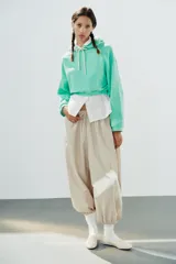 Pantalón de tiro medio y cintura elástica con cordón de ajuste, bolsillos laterales y bajo abullonado con puños elásticos. Confeccionado en poliamida.