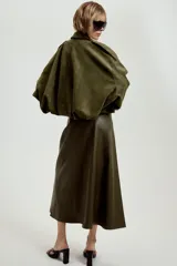 Chaqueta de efecto ante color marrón claro, con cuello solapa, manga larga con trabillas en los hombros y bajo abullonado. Cierre frontal con cremallera y botones ocultos por solapa.