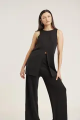 Blusa tejida de cuello redondo y sin mangas, con un tajo frontal central que le otorga un diseño moderno y fluido.