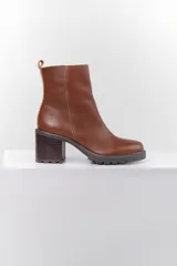 Botas de cuero color marrón con caña corta, taco cuadrado y suela track.