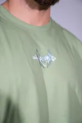 Musculosa verde militar de algodón elastizado, con cuello redondo y diseño holgado sin mangas. Cuenta con pequeño estampado gráfico en el centro del pecho.