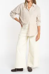 Pantalón tipo jean de corte wide leg y tiro medio, confeccionado en algodón peinado de color crudo.