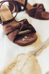 Sandalia de tacón cuadrado medio, confeccionada en terciopelo negro. Presenta un diseño de tiras cruzadas con nudo en la parte delantera y una tira ajustable con hebilla en el tobillo.