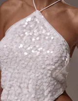 Top blanco con textura, escote halter y espalda descubierta.