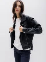 Chaqueta biker negra de cuero sintético, con cierre asimétrico frontal, bolsillo con cierre a la vista y bolsillo con solapa. Incluye cinturón con hebilla en la cintura.