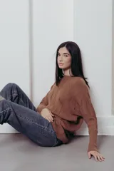 Sweater de punto con textura de ochos verticales, cuello redondo, mangas largas con puños acanalados y silueta relajada.