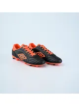 Championes de fútbol Umbro modelo Touch FG, color negro con detalles en turquesa. Presentan el logo de la marca en el lateral y suela con tapones para terreno firme.