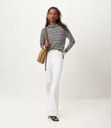 Sweater de punto de manga larga, con rayas horizontales en azul marino y blanco. Presenta cuello redondo ligeramente elevado y puños y ruedo en color blanco liso.