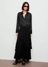 Camisa de mujer con acabado satinado, diseño recto, cuello camisero, manga larga con puños abotonados y cierre frontal con botones.