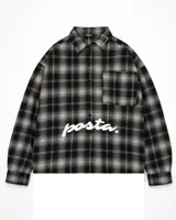 Camisa de manga larga con corte boxy fit, confeccionada en algodón a cuadros en tonos negro y gris. Presenta un bolsillo frontal en el pecho y el texto 'posta.' estampado en color blanco en la parte delantera.