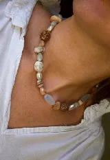 Collar corto de piedras naturales y cuentas en tonos tierra, beige y celeste.