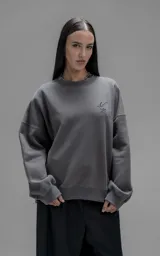 Buzo de cuello redondo confeccionado en frisa de algodón, con diseño de hombros caídos y logo bordado en el frente. Presenta terminaciones en punto rib en cuello, puños y ruedo.