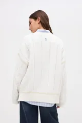 Buzo de punto tejido en algodón, con diseño de ochos y detalles en color blanco en sisas y ruedo. Presenta cuello redondo y calce holgado.