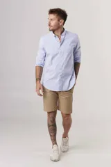 Camisa de hombre color crema, de corte clásico, con cuello abotonado y mangas largas.