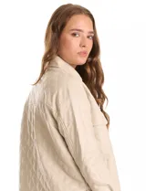 Chaqueta de eco cuero negro con diseño capitoneado, cuello con solapa y cierre frontal con botones a presión. Presenta mangas largas con puños abotonados, dos bolsillos frontales con solapa y forro interno a tono.