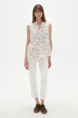 Musculosa sin mangas con cuello en V y calce holgado, confeccionada en tela estampada con motivos florales en tonos azules sobre fondo claro.