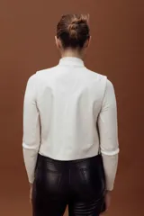 Chaleco de cuero ovino con diseño sastrero minimalista, escote en V, cierre frontal con botones y bolsillos laterales con vivo.