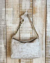 Cartera de hombro color beige con textura tipo cocodrilo, confeccionada en gamuza. Presenta un diseño estructurado con una cadena metálica decorativa en la parte superior del asa y cierre principal.