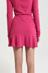 Minifalda fucsia de elastano, ajustada al cuerpo, con detalle de frunces en el frente, volado en el ruedo y cintura con elástico interno.