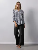 Blusa de gasa estampada multicolor, marca Ruby Rd. Tiene cuello a la base, escote en V, abertura central con botones y plisados en la parte delantera. Las mangas son 3/4 y tienen un largo regulable con presilla y botón.