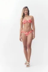 Bombacha de bikini color naranja con estampado tropical de palmeras y flores blancas, con tiras laterales para atar con lazo.