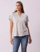 Remera gris a rayas horizontales blancas, con cuello a la base y escote en V. Manga corta con presilla y botón.