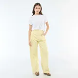 Pantalón de corte globo en color amarillo pastel, con tiro alto, cierre frontal con botón y bolsillos laterales.