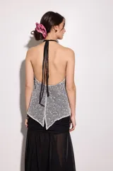 Top negro reversible de gasa y red, con corte fluido en el pecho y espalda descubierta.