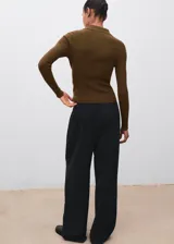 Jersey de punto fino con diseño acanalado, cuello tipo polo con cierre frontal de botones y manga larga. Presenta un corte entallado al cuerpo.