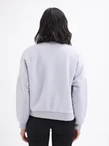 Campera tipo bomber de felpa color gris claro, con cierre frontal completo, cuello redondo y puños elásticos acanalados.
