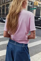 Remera de algodón color rosado, con cuello redondo decorado con una aplicación de joyas y pedrería, manga corta y corte regular.