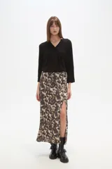 Falda larga de corte recto con abertura lateral pronunciada, confeccionada en tejido fluido con estampado abstracto en tonos tierra y crema.