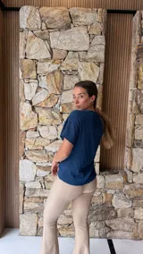 Blusa de manga corta color azul oscuro con textura arrugada o plisada, cuello redondo con borde festoneado.