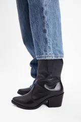 Botineta estilo texano de cuero vacuno color negro, con taco cuadrado y punta fina.