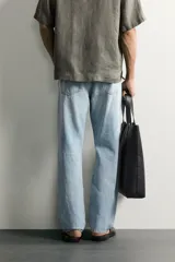 Jeans regular fit confeccionados en denim de algodón celeste con efecto lavado, de cinco bolsillos y cierre frontal con cremallera y botón.