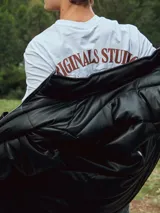 Campera puffer negra de cuero sintético con cierre frontal y cuello alto.