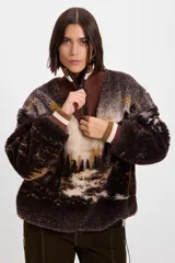 Buzo de tejido de punto jacquard con textura de pelo, con diseño estampado de paisaje de bosque. Presenta cuello alto con cierre frontal parcial, puños acanalados en tonos marrón y crema, y un parche decorativo en la manga.