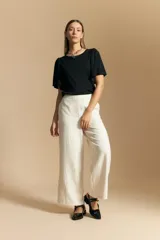 Remera de rib color beige, con cuello redondo y mangas cortas amplias con leve frunce en los hombros. Confeccionada en tejido elastizado de textura acanalada.