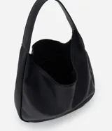 Cartera modelo hobo de gran tamaño confeccionada en poliuretano con textura granulada. Presenta un diseño de media luna con asa única integrada, cierre superior con cremallera y un compartimento interior amplio con bolsillo.