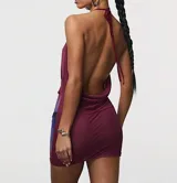 Vestido corto de satén con escote profundo tipo halter y espalda descubierta. Presenta un diseño estampado con degradado en tonos bordó y violeta.