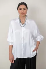 Camisa de satén tramada color blanco, con calce holgado y cómodo, cuello camisero, mangas largas y cierre frontal con botones.