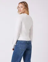 Buzo de punto marca Zac & Rachel en color blanco, con cuerpo de textura acanalada y mangas largas con diseño de punto calado. Presenta cuello redondo a la base y puños ajustados.