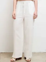 Pantalón de lino color crudo, de corte recto y tiro alto, con cintura elástica y cordón ajustable.